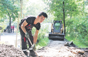 15 июня 2016 года. Рабочий Тимур Очилов устанавливает бордюрный камень вдоль дорожки