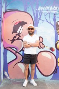 11 августа 2016 года. Уличный художник граффити Илья Бодров на фоне своей «личной» стены с изображением зайцев