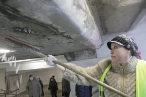 Фото: 7 ноября 2016 года. Сотрудница подрядной организации сбивает сосульки с оштукатуренного потолка вестибюля станции метро «Полянка» 