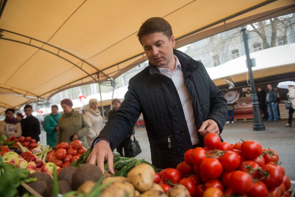 7 апреля 2017 года. Глава Департамента торговли и услуг Алексей Немерюк приценивается к помидорам, которые предлагают на ярмарке на Школьной улице