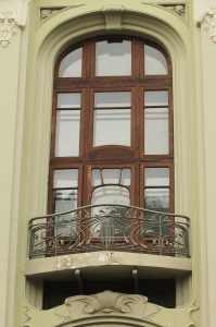 Пластику фасада дома подчеркивают узорные решетки балконов, расположенных на втором, третьем и четвертом этажах, а также необычный рисунок конных переплетов.