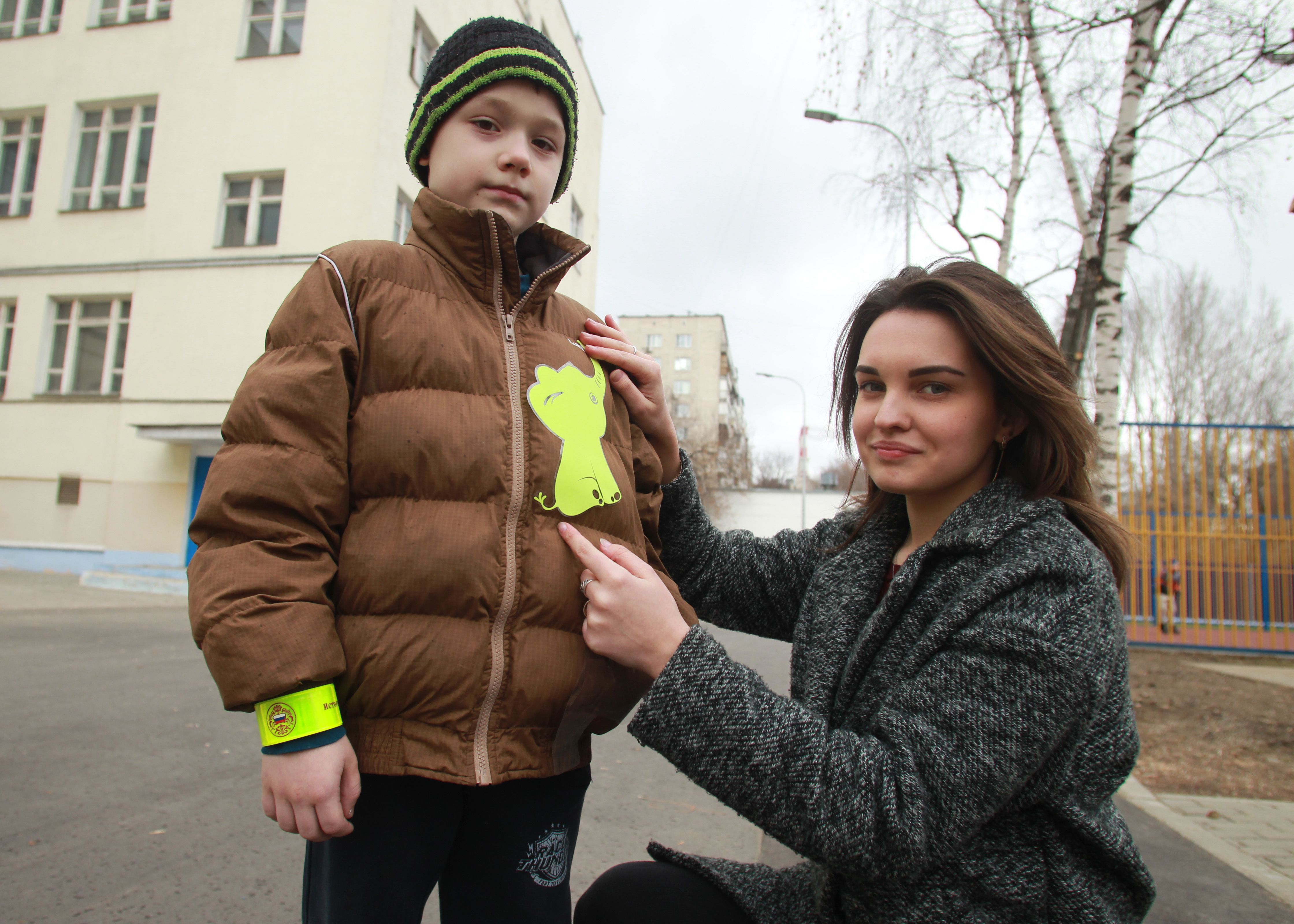 1 апреля 2019 года. Москвичка Екатерина Трубникова наклеивает на куртку Рамиля Зирхарняева светоотражатель в виде слона. Фото: Наталия Нечаева, «Вечерняя Москва»