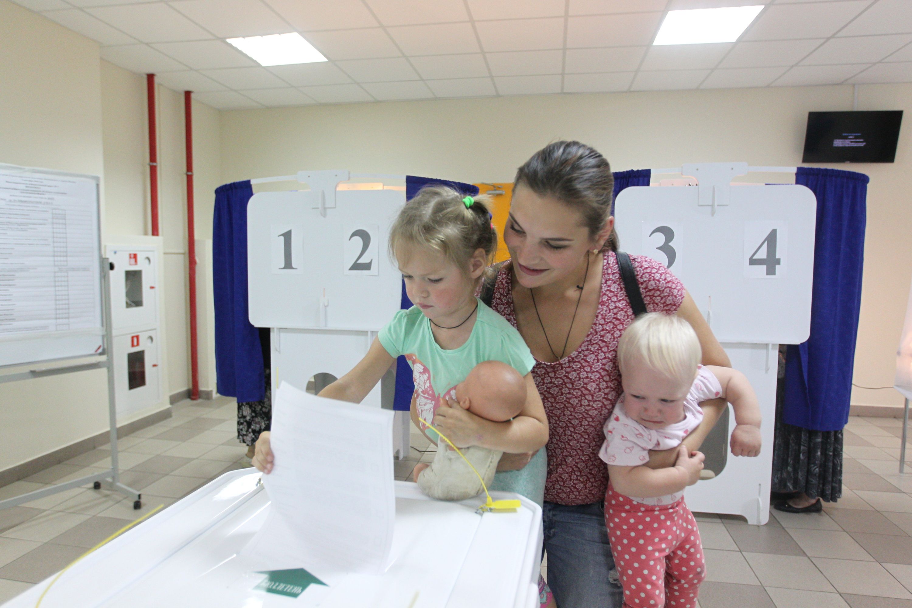 2018 год. Оксана Крючкова с дочками Валерией (слева) и маленькой Настей на избирательном участке. Фото: Владимир Смоляков