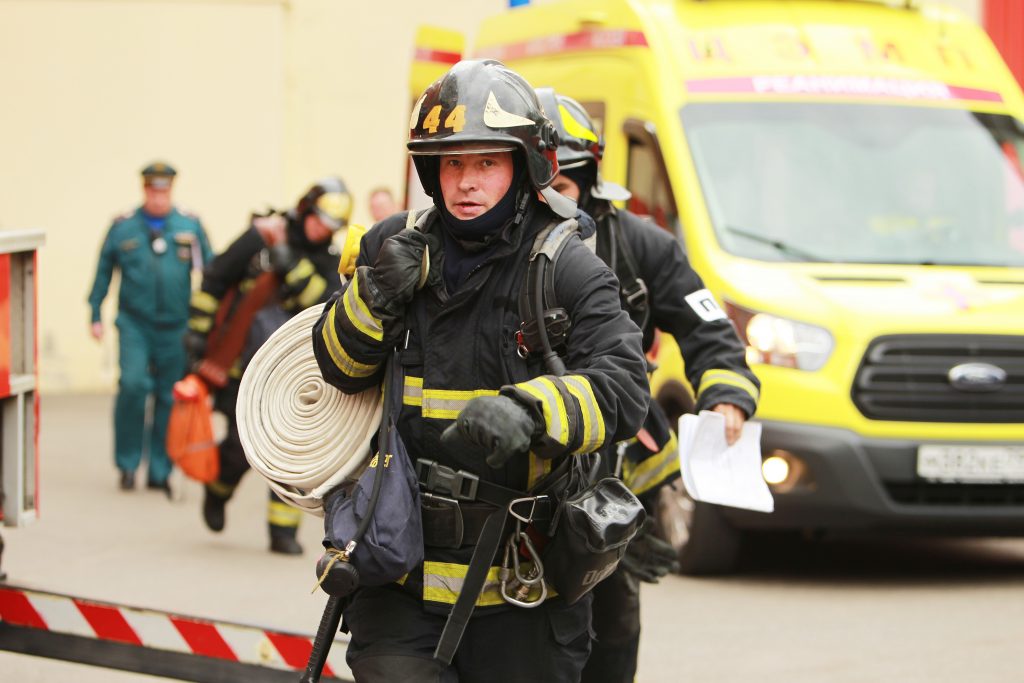 Виталий Бурлий разворачивает скатку пожарного рукава. Фото: Наталия Нечаева, «Вечерняя Москва»