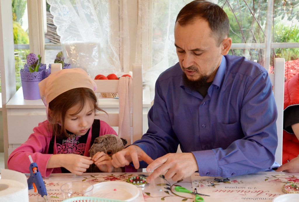 Вячеслав Кусаинов вместе с маленькой дочкой выбирает самые красивые бирюзовые стразы для зеркала. Фото: Анна Быкова