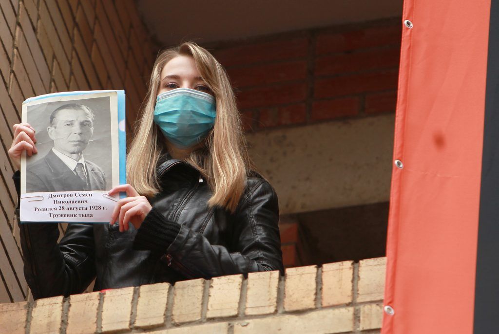 Жительница ЦАО Кристина Топорекова вышла на балкон с портретом родственника. Фото: Наталия Нечаева, «Вечерняя Москва» 