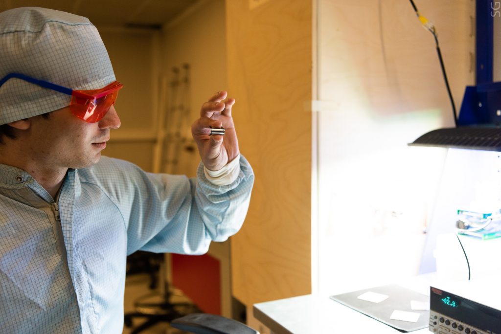 31 августа 2020 года. Инженер университета «МИСиС» Данила Саранин проверяет солнечную батарею (1), которая выполнена в форме небольшого стикера и легко крепится к гаджету (2). Фото: пресс-служба МИСиС