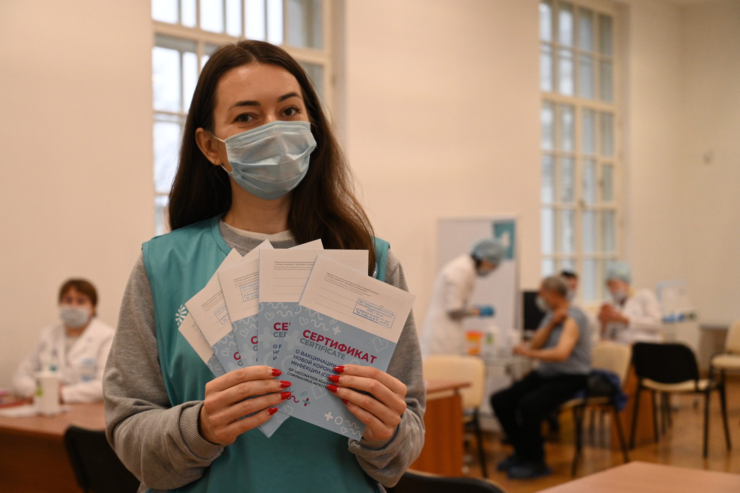 Социальный помощник Наталья Пасютина держит сертификаты, которые выдают вакцинированным от COVID-19. Фото: Алексей Орлов
