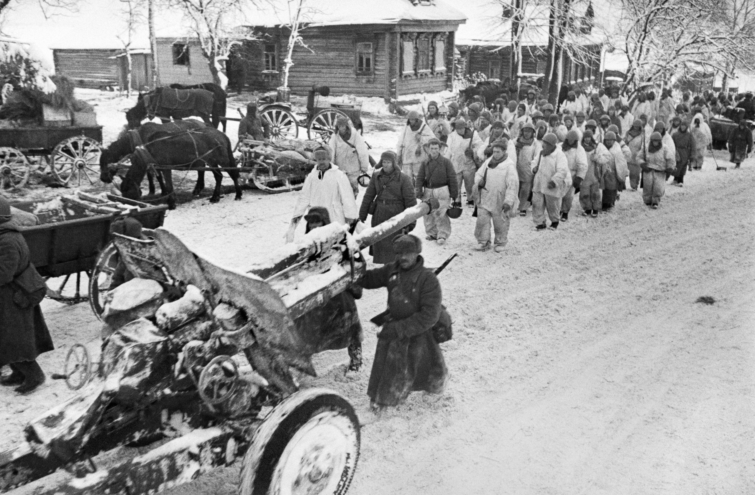 6 декабря 1941 года. Советские войска проходят по улице освобожденной деревни в Московской области (1). Фото: Самарий Гурарий , «РИА новости»