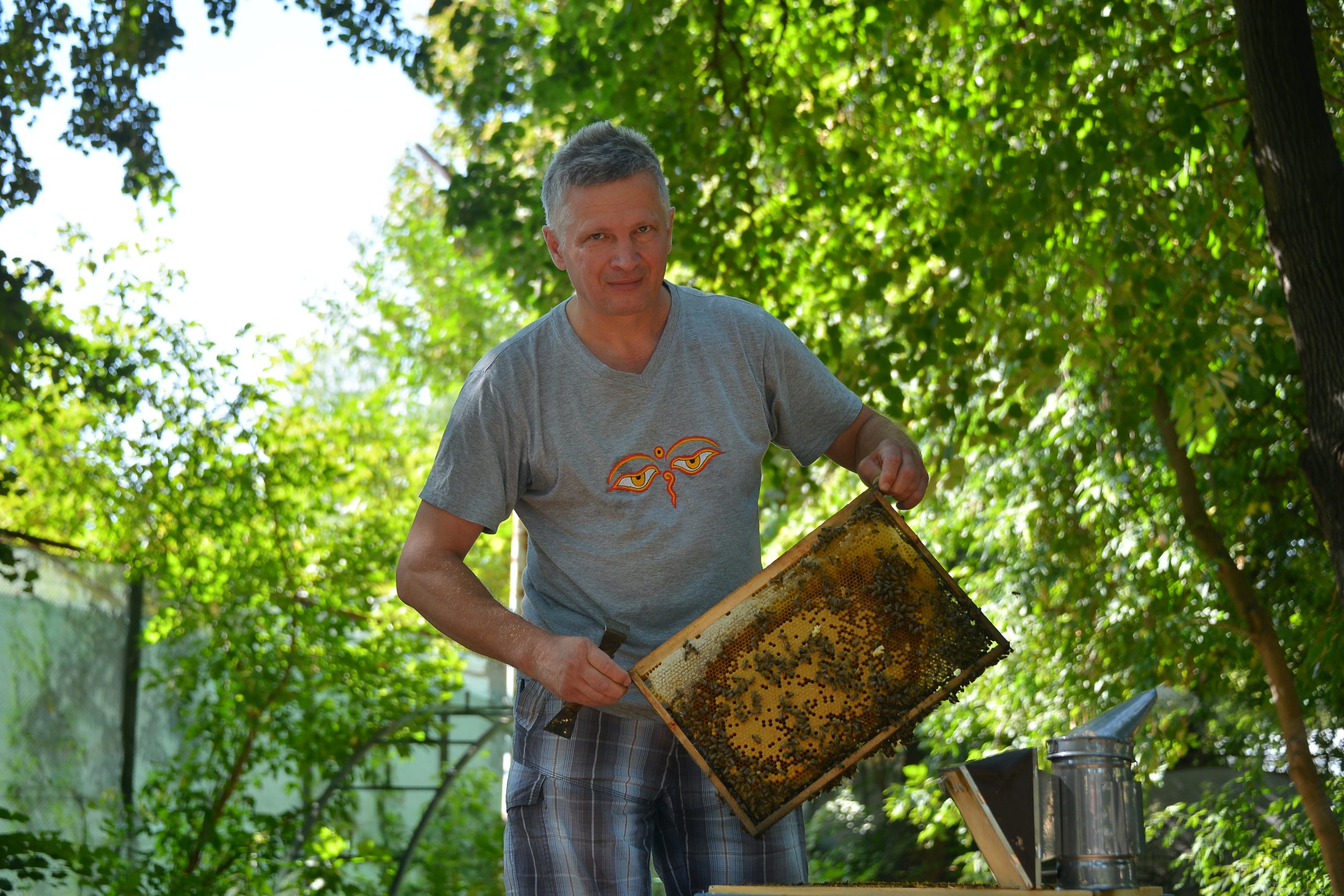 16 августа 2022 года. Пчеловод Евгений Сухов держит в руках соты ульев с собственной пасеки. Фото: Анна Макмаладзе, «Вечерняя Москва»