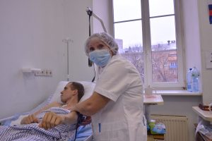 Медсестра Валентина Питерцева измеряет давление пациенту Илье. Молодой человек восстанавливается после контузии. Фото: Анна Малакмадзе, «Вечерняя Москва»